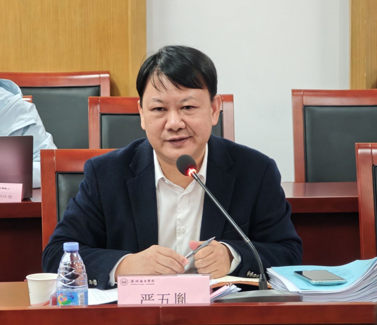 桌子前坐着穿西装的男子AI 生成的内容可能不正确。